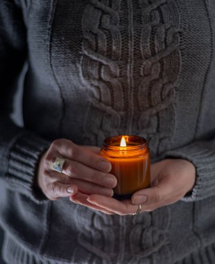Elinde bir soya mumu tut ve yak. Kavanozda mum. Aromatheramia. Aroma mumu.