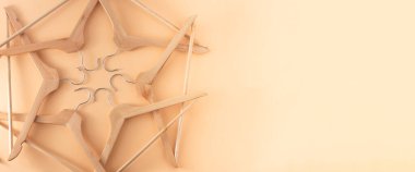 Elbise askıları. Askı hazır. Bej arkaplan kopyalama alanı afişi. Tahta askılar. Dükkan.