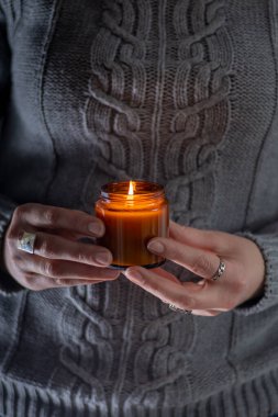 Elinde bir soya mumu tut ve yak. Kavanozda mum. Aromatheramia. Aroma mumu.