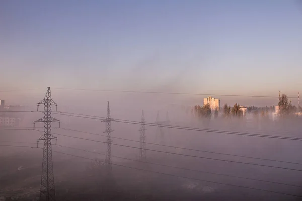 Mlha a smog ve městě. Elektrické vedení. Pólové dráty. Pohled shora z okna. Ráno ve spacím prostoru. — Stock fotografie