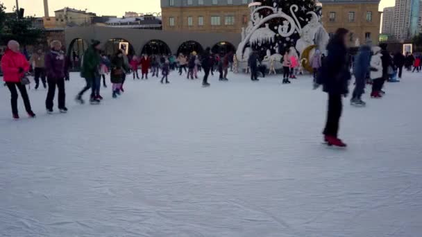 Pista de patinaje sobre hielo en invierno. La gente patina. Patines montados sobre hielo. El patinaje sobre hielo es un deporte de invierno y entretenimiento. Las mujeres, los niños, las piernas de hombre van. — Vídeo de stock