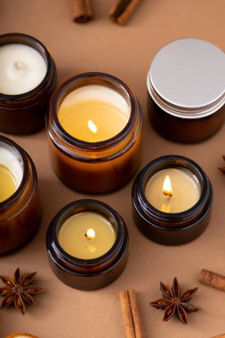 Beyaz arka planda cam kavanozlarda farklı aroma mumları. Kokulu el yapımı mum. Soya mumları kavanozda yanıyor. Balmumu ve parafin kavanozda.