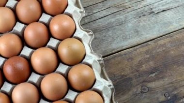 Yumurta arkaplanı. Karton tepside kahverengi yumurtalar. Protein yiyeceği. Çiftlikte tavuk yumurtası paketliyorum. Çevresel.