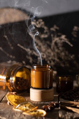 Kahverengi cam kavanozlarda farklı aroma mumları. Kokulu el yapımı mum. Soya mumları bir kavanozda yanıyor. Aromaterapi ve spa 'da ve evde rahatlamak..