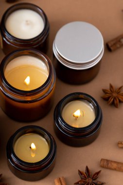 Kahverengi cam kavanozlarda farklı aroma mumları. Kokulu el yapımı mum. Soya mumları bir kavanozda yanıyor. Aromaterapi ve spa 'da ve evde rahatlamak..