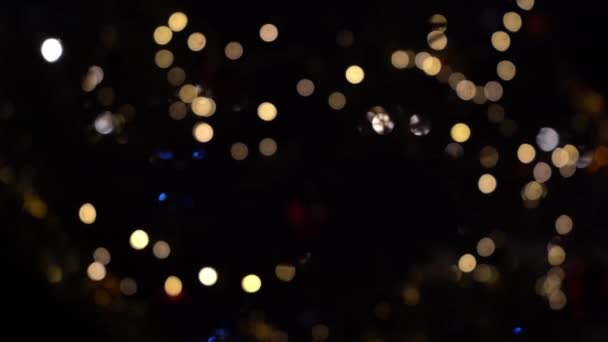 ガーランドのライトのボケ 焦点をぼかした ガーランドが点滅している 夜の街の灯 クリスマス気分 要約ぼやけたクリスマスツリーのちらつき 冬休みのコンセプト — ストック動画
