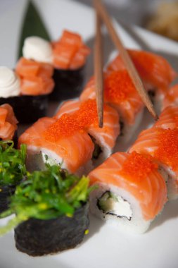 Somon suşi seti. Suşi Philadelphia 'yı kırmızı balıklı, somonlu, kırmızı havyarlı. Masaj havyarının altında yumuşak avokado ve krem peynirle yuvarlan. Klasik suşi. Gıda arkaplanı
