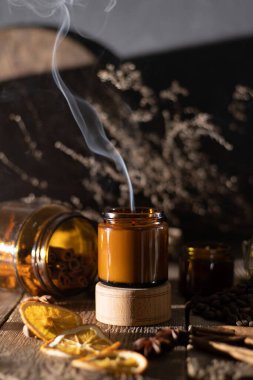Kahverengi cam kavanozlarda farklı aroma mumları. Kokulu el yapımı mum. Soya mumları bir kavanozda yanıyor. Aromaterapi ve spa 'da ve evde rahatlamak..