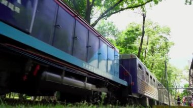 Ukrzaliznytsia. Tren ve vagonlar hareket ediyor. Oyuncak demiryolu. Çocuklar ve çocuklar için parkta bir gezi treni. Lokomotif. Ukrayna, Kyiv - 4 Temmuz 2022.