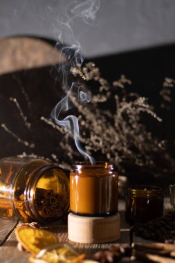 Kahverengi cam kavanozlarda farklı aroma mumları. Kokulu el yapımı mum. Soya mumları bir kavanozda yanıyor. Aromaterapi ve spa 'da ve evde rahatlamak..