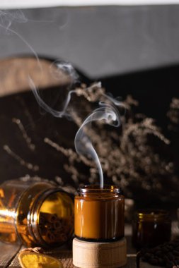 Kahverengi cam kavanozlarda farklı aroma mumları. Kokulu el yapımı mum. Soya mumları bir kavanozda yanıyor. Aromaterapi ve spa 'da ve evde rahatlamak..