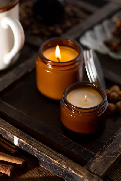 A set of different aroma candles in brown glass jars. Scented handmade candle. Soy candles are burning in a jar. Aromatherapy and relax in spa and home.