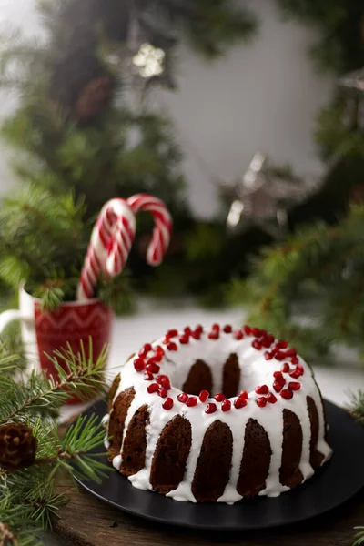 クリスマス フード 白いアイシングで丸いパイ ザクロの真ん中に穴のあるカップケーキ テーブルの上に緑のトウヒの枝 まだ生きてる 甘いペストリー デザート お正月のお菓子 — ストック写真