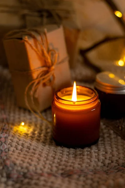 A set of different aroma candles in brown glass jars. Scented handmade candle. Soy candles are burning in a jar. Aromatherapy and relax in spa and home.