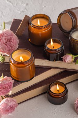 A set of different aroma candles in brown glass jars. Scented handmade candle. Soy candles are burning in a jar. Aromatherapy and relax in spa and home. Fire in brown jar.
