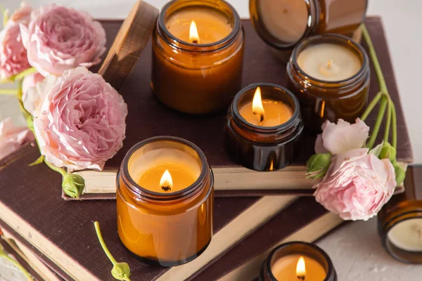 A set of different aroma candles in brown glass jars. Scented handmade candle. Soy candles are burning in a jar. Aromatherapy and relax in spa and home. Fire in brown jar.