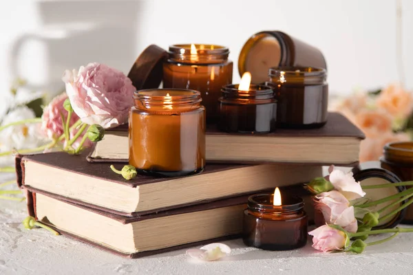 A set of different aroma candles in brown glass jars. Scented handmade candle. Soy candles are burning in a jar. Aromatherapy and relax in spa and home. Fire in brown jar.