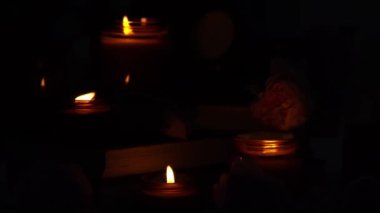 A set of different aroma candles in brown glass jars and flowers. Scented handmade candle. Soy candles are burning in a jar. Aromatherapy and relax in spa and home. Fire in brown jar. Dark evening