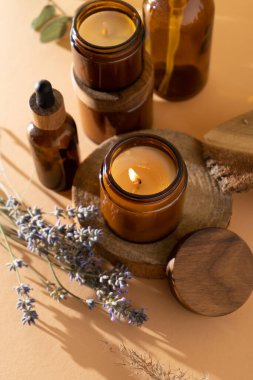Cam kavanozdaki soya mumları. Aromaterapi. Yanan mum ve lavanta. Kavanozlar için tahta kapak. Bej arka plan. Rahatlık ve rahatlama. El yapımı. Ev dekoru.