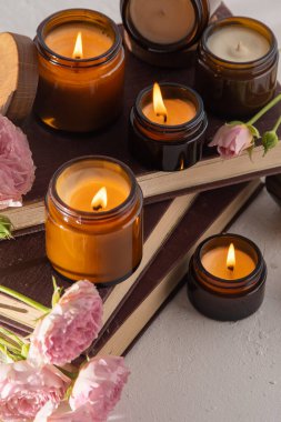 A set of different aroma candles in brown glass jars. Scented handmade candle. Soy candles are burning in a jar. Aromatherapy and relax in spa and home. Fire in brown jar.