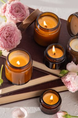 A set of different aroma candles in brown glass jars. Scented handmade candle. Soy candles are burning in a jar. Aromatherapy and relax in spa and home. Fire in brown jar.