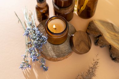 Cam kavanozdaki soya mumları. Aromaterapi. Yanan mum ve lavanta. Kavanozlar için tahta kapak. Bej arka plan. Rahatlık ve rahatlama. El yapımı. Ev dekoru.