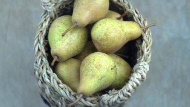 Ahşap bir arka planda sepetteki armutlar. Meyve hasadı. Sonbahar hala hayattır. Armut çeşitliliğinde Bera Konferansı. Vitamin yiyeceği..