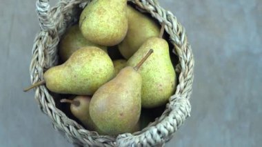 Ahşap bir arka planda sepetteki armutlar. Meyve hasadı. Sonbahar hala hayattır. Armut çeşitliliğinde Bera Konferansı. Vitamin yiyeceği..