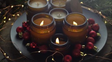 Soya mumları cam kavanozlarda yanar. Evdeki rahatlık. Kahverengi kavanozdaki mum. Koku ve ışık. Kokulu el yapımı mum. Aroma terapisi. Noel ağacı ve kış havası. Sıcak ev dekorasyonu. Kırmızı toplar dekorasyonu