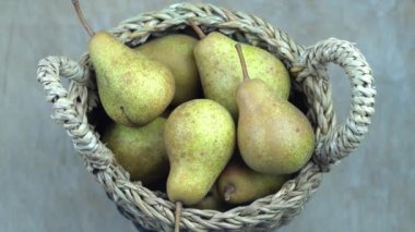 Ahşap bir arka planda sepetteki armutlar. Meyve hasadı. Sonbahar hala hayattır. Armut çeşitliliğinde Bera Konferansı. Vitamin yiyeceği..