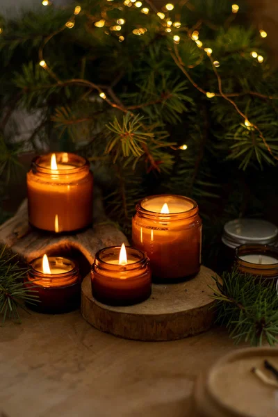 Soya mumları cam kavanozlarda yanar. Evdeki rahatlık. Kahverengi kavanozdaki mum. Koku ve ışık. Kokulu el yapımı mum. Aroma terapisi. Noel ağacı ve kış havası. Sıcak ev dekorasyonu. Şenlikli dekorasyon.
