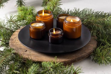 Soya mumları cam kavanozlarda yanar. Evdeki rahatlık. Kahverengi kavanozdaki mum. Koku ve ışık. Kokulu el yapımı mum. Aroma terapisi. Noel ağacı ve kış havası. Hoş bir dekor. Şenlikli dekorasyon