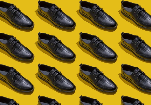 靴のパターン 影と黄色の背景上のビューに黒い靴 アクセサリーコンセプト 新しい革の靴 古典的なオフィススタイル メンズファッションシューズ フラットミニマリズムストア広告 — ストック写真