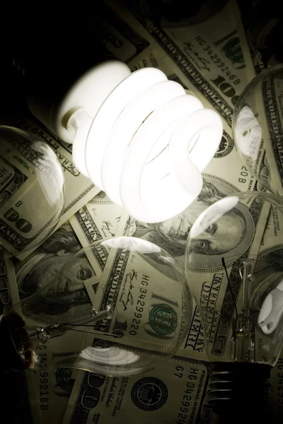 Лампочка и доллар — стоковое фото