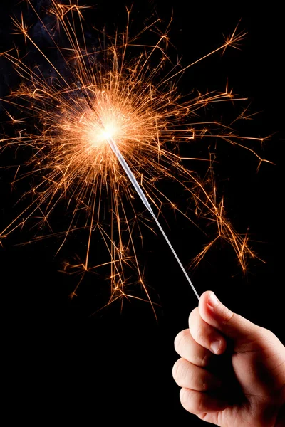 Child's hand, holding a burning sparkler. — Stock Photo, Image