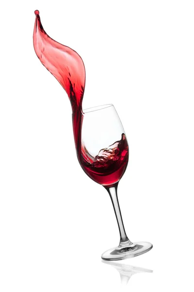 Красное вино брызгает из стекла . — стоковое фото