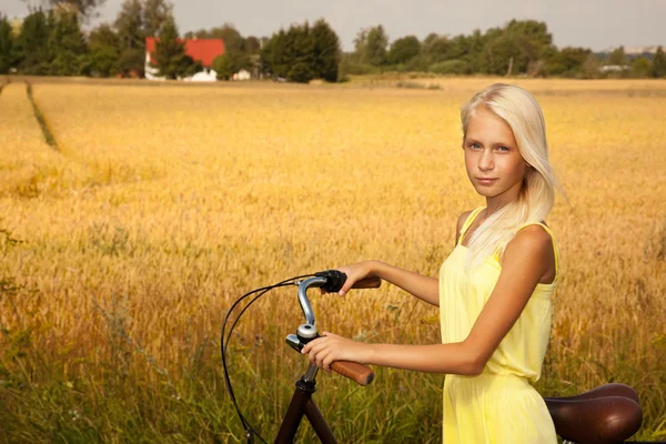 Jovem com uma bicicleta no campo . Imagens De Bancos De Imagens