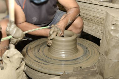 Bir çömlekçinin yakın çekim elleri çömlekçinin tekerinde esrar yaratıyor. Geleneksel el yapımı. Çamurdan el yapımı esrar. 