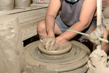 Bir çömlekçinin yakın çekim elleri çömlekçinin tekerinde esrar yaratıyor. Geleneksel el yapımı. Çamurdan el yapımı esrar. 