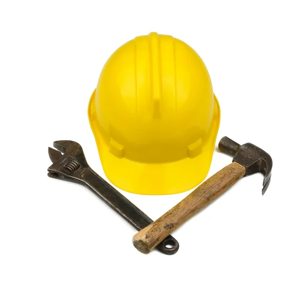Gul hardhat med korsade hammare och skiftnyckel — Stockfoto
