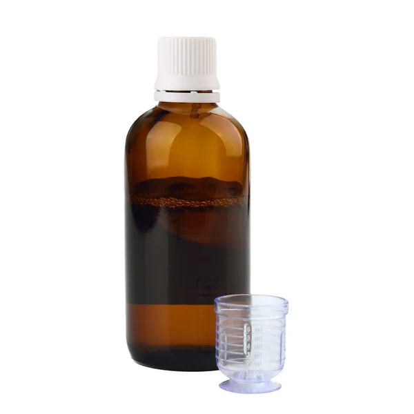 Syrup in a bottle with dosage cup — Stock Photo, Image