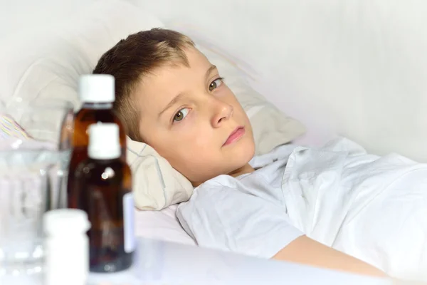 Zieke kleine jongen in het bed — Stockfoto