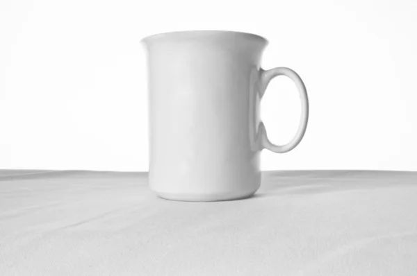 Copo branco na toalha de mesa branca — Fotografia de Stock