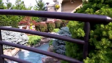 Beautiful fountain in the summer garden. Stones in the water. Beautiful flowers in the fountain.