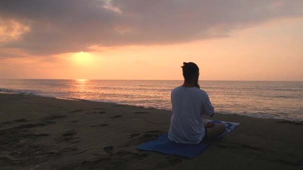 Mann meditiert am Strand — Stockvideo