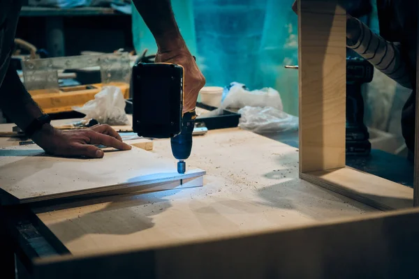 İnsanlar marangozluk atölyesinde çalışıyor.