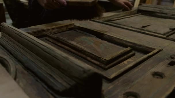 Hombre cepillos vieja puerta de madera — Vídeos de Stock