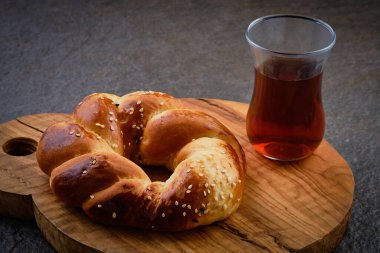 Geleneksel çay bardağında Türk hamur tatlısı ve çayı koyu arkaplanda tahta tahtada