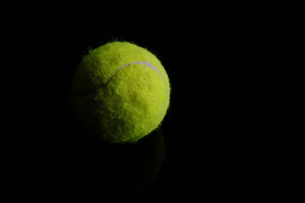 Grüner Tennisball auf schwarzem Hintergrund — Stockfoto