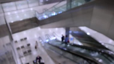 Havaalanında yürüyen merdivendeki insanlar.